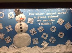 a snowman made out of paper on display in front of a bulletin board that says it's snow secret we're a great school, we use the 7 habitts