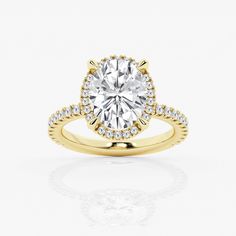 a yellow gold engagement ring with an oval cut diamond in the center