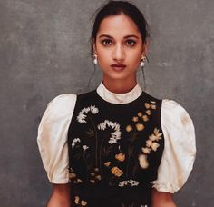 a woman in a black and white dress with flowers on it