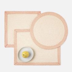 two placemats, one with an apple and the other with a plate on it