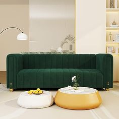 a living room with a green couch and two white tables in front of the wall