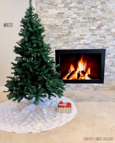 a small christmas tree sitting in front of a fireplace