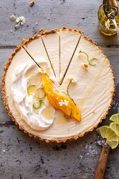 there is a pie on the table with lemons and other toppings around it