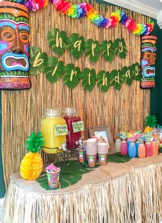 a table topped with lots of food next to a tiki mask and wall decoration