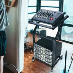 a man standing in front of a sound mixing equipment set up on top of a wooden floor