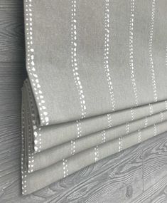 a gray and white striped curtain hanging on the side of a wall