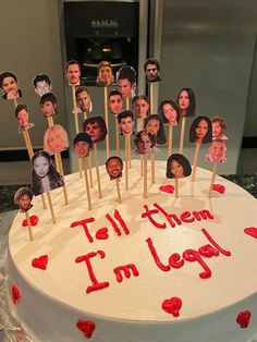 a white cake with red icing and pictures of people on it that says tell them i'm legal