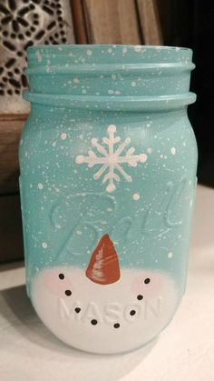 a mason jar with a snowman face painted on it