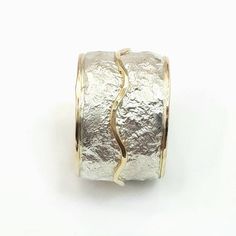 This is a wide, bold ring, chunky but not heavy, that makes a statement. It has a crumpled tinfoil texture with a wavy gold stripe soldered on top. Width: 0.56 inch / 14 mm Thickness: 0.1 inch / 2.5 mm This listing is for sizes 4-13- Just convo me your size. For other sizes - please convo me. Additional information If you liked this item, you may also want to look at these pieces: http://etsy.me/2fWkafJ http://etsy.me/2eI2vT3 For customer reviews of our shop: http://etsy.me/2eOQZZt Back to our s Unique Hammered Wide Band Rings, Elegant Wide Band Hand Cast Jewelry, Elegant Hand Cast Wide Band Jewelry, Unique Silver Jewelry With Unique Texture, Silver Jewelry With Unique Texture, Wide Band Silver Hammered Jewelry, Unique Wide Band Hammered Jewelry, Hammered Wide Band Ring As Gift, White Gold Jewelry With Hammered Wide Band