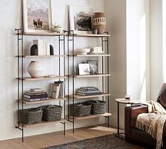 a living room filled with furniture and bookshelves next to a wall mounted painting