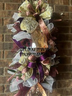 a purple and white wreath hanging on the side of a brick wall