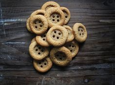 a pile of cookies sitting on top of a wooden table with holes in the middle