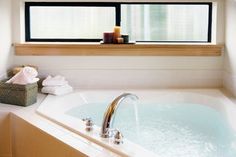 a bathroom with a large jacuzzi tub and two candles on the window sill