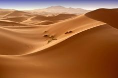 the desert is filled with sand dunes and mountains