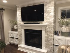 a fireplace with a flat screen tv mounted on it's mantle in a living room