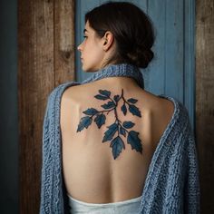 the back of a woman's shoulder with leaves on her upper and lower back