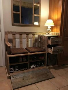 a wooden bench with several pairs of shoes on it in front of a mirror and lamp