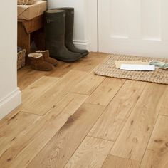 a pair of boots sitting on top of a wooden floor next to a white door