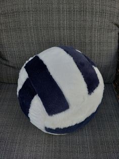 a blue and white ball sitting on top of a gray couch