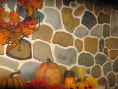 a stone wall with pumpkins and other autumn decorations