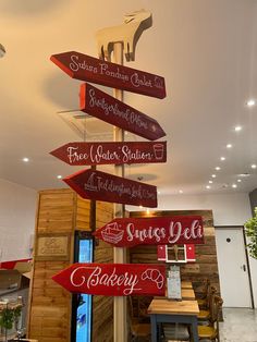 several signs are hanging from the ceiling in a restaurant that is decorated with wood planks