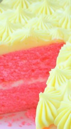 a close up of a slice of cake with white frosting and pink sprinkles