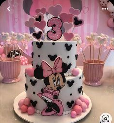 a minnie mouse birthday cake with pink and black decorations