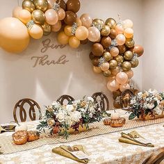 the table is set with gold and white balloons