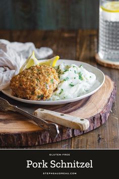 pork schnitzel on a plate with mashed potatoes and lemon wedges