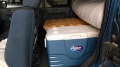 the back end of a blue van with coolers in it's cargo area