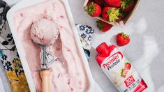 two scoops of ice cream and strawberries on a table