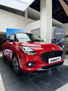 a red car is on display in a showroom