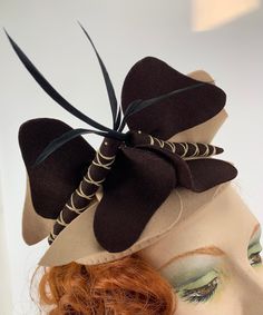 1930'S-1940'S Butterfly Fascinator Hat in the shape of a small skull cap of beige felt. There are 2 felt butterflies in beige & chocolate felt on top of this hat with goose biot feathers as antennae.. Beautifully handmade by Mabel's Millinery. So stinking cute!!- A terrific Novelty Butterfly Hat.  This is in EXCELLENT VINTAGE CONDITION.. with some slight imperfections on the surface of the beige felt.. but not a big deal.  Generally with these small skull like caps there are little combs sewn in to the inside of the hat, but there are none on this. I'm sure the user used hair pins to secure to her hair. Label reads:  MABEL'S 1903 E Lake Street Minneapolis, Minnesota Measurements: 8 inches in diameter x 6 inches tall Adjustable Brown Hat With Structured Crown, Adjustable Brown Hats For Evening, Vintage Brown Top Hat For Costume, Vintage Brown Hat For Halloween, Brown Vintage Top Hat For Costume, Fitted Brown Costume Hats For Kentucky Derby, Brown Fitted Fascinator Hat, Brown Hat Fascinator For Kentucky Derby, Adjustable Brown Hat Fascinator