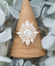 a diamond ring sitting on top of a wooden cone