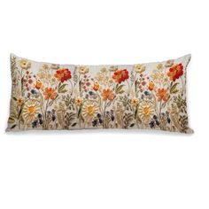 an embroidered pillow with colorful flowers on the front and back, sitting on a white surface