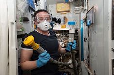 a man in protective gear holding a blow dryer