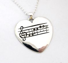 a heart shaped necklace with musical notes on it