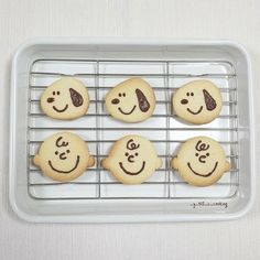 cookies with faces drawn on them sitting on a cooling rack