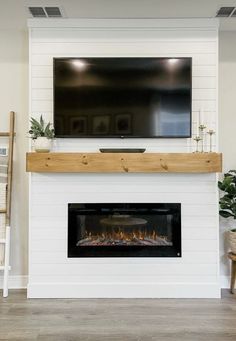 a white fireplace with a flat screen tv above it