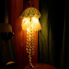 a lamp that is sitting on top of a wooden table in front of a curtain