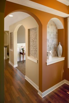 an archway between two walls in a house with wood floors and hard wood flooring