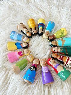 a group of wooden toy figures sitting on top of a white rug