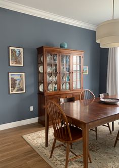 a dining room with blue walls and wooden furniture