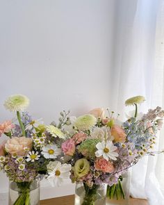 two vases filled with flowers sitting on a table