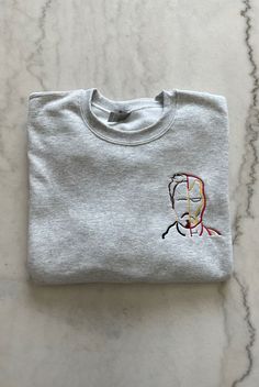 a t - shirt with the image of a man's face embroidered on it