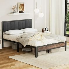 a bed sitting in a bedroom on top of a hard wood floor next to a window