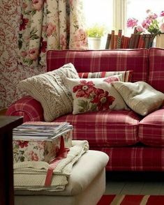 a living room filled with furniture and flowers on the window sill in front of it