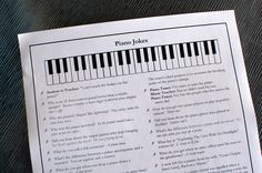 a sheet with piano notes on it sitting on top of a wooden table next to a keyboard