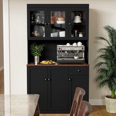 a dining room table with two chairs and a coffee maker on top of the hutch