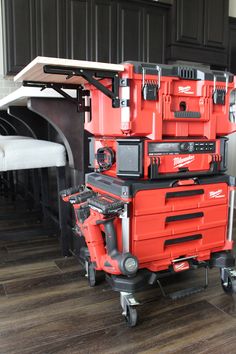 a red tool box sitting on top of a wooden floor